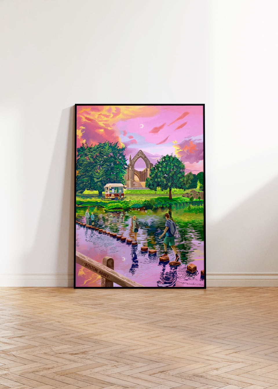 artwork of a scenic landscape featuring Bolton Abbey in North Yorkshire, with a church and people on a bridge, displayed on a white wall.